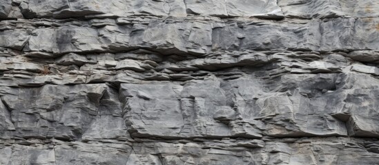 Poster - Textured stone wall background in shades of gray with layered rock formations creating a rustic and natural appearance ideal for design use.
