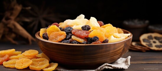 Poster - Bowl overflowing with vibrant dried fruits including pineapples and apricots positioned center on rustic table against dark background.