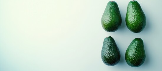 Poster - Four fresh green avocados arranged in a group on a light gray background highlighting their vibrant color and natural appeal for culinary themes