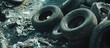 © Nijat - Scattered worn-out tires amidst debris and refuse, featuring dark rubber textures and contrasting metallic bits in the background, creating an industrial scene.