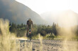 © Cavan Images - biker on a gravel path during golden hour in a calm valley.