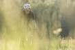 © Cavan Images - Gravel biker on a dirt path during golden hour in a serene valley