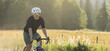 © Cavan Images - Cyclist riding a dirt trail surrounded by nature in a quiet rural area