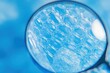 © MuhamadNoorHazwan - Close-Up View of Soap Bubbles under Magnifying Glass with Vibrant Blue Background, Capturing Intricate Patterns and Textures of Bubbles in Background Detail