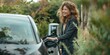 © YURIMA - Smiling woman in casual attire plugs in her electric car at an outdoor charging station amidst lush greenery. Capturing the essence of eco-friendly commuting and sustainable energy use.
