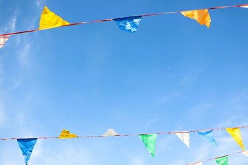 vibrant and colorful festival bunting hanging beautifully against a bright blue sky above