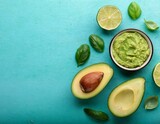 sliced avocados lime basil and guacamole on a blue turquoise table healthy nutrition good fat omega 3 recipe concept with empty space for text