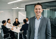 © OlehStock - Man smiling and standing in a modern office