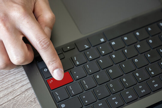 A keypad of laptop with finger hit on enter button