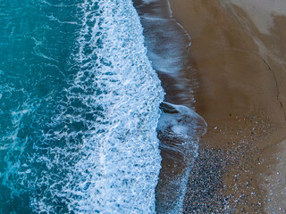 Wall Mural - Ocean waves crashing on sandy beach. Aerial view.