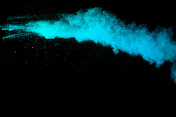 Wall Mural - Abstract green blue powder explosion on black background. Blue dust on dark