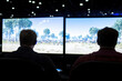 © jr-art - Two men are playing a video game on a large screen