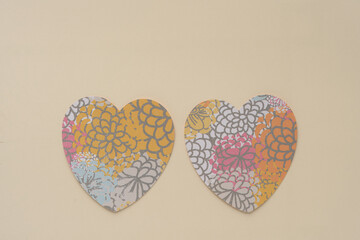 Wall Mural - two hearts machine-cut from decorative scrapbooking paper featuring floral pattern arranged side by side on blank beige paper