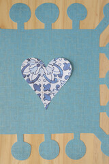 Wall Mural - paper hearts machine-cut from decorative tile-themed scrapbooking paper and arranged on blue paper with large coronet edge and wood