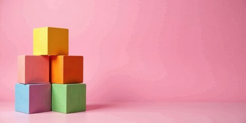 Poster - Pastel-colored blocks arranged in a pyramid shape against a soft pink background, symbolizing growth, development, and the building blocks of success