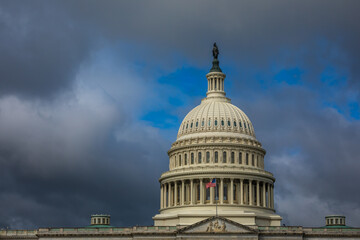 Wall Mural - US Capitol Building in Washington, DC - Partial View of the Dome with US Flag; dark Clouds in Background; Close-up with Copy Space