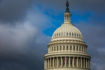 Wall Mural - US Capitol Building in Washington, DC - Partial View of the Dome with US Flag; dark Clouds in Background; Close-up with Copy Space