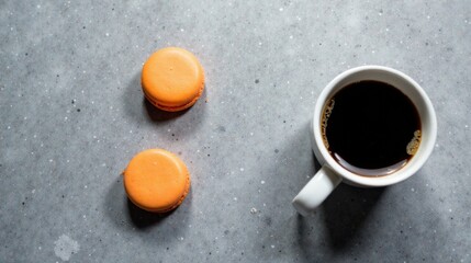 Poster - Aromatic Coffee Break with Two Delightful Orange Macarons on a Textured Surface