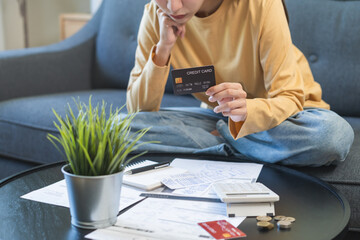 Wall Mural - Business financial concept, stressed asian young business woman hand holding credit card for calculate accounting expense of bill, tax for payment on due deadline, trying to find money to pay debt.