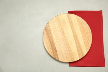 Wall Mural - Red napkin and empty wooden board on grey table, top view. Space for text