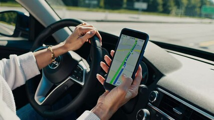 Poster - Woman driving car while navigating with smartphone gps app, gripping steering wheel and checking digital route guidance on mobile screen