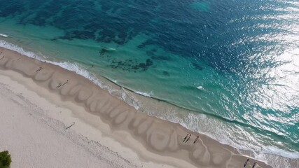 Poster - Crystal clear turquoise waves rhythmically caress the pristine white sand of a serene beach, creating a mesmerizing dance of nature's beauty