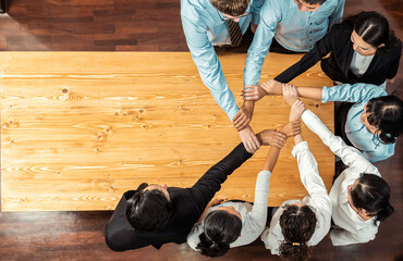 Wall Mural - Multicultural business people holding hand together in circle. Unity teamwork in office business workplace. Diverse ethnic office worker engaged in team building. Panorama top view. Meticulous