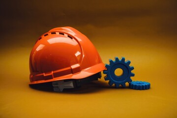 Poster - An orange hard hat rests beside two blue gears, symbolizing construction and engineering.