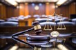© darshika - A wooden gavel and scales of justice in a courtroom.