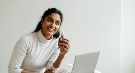 Canvas Print - Woman is sitting on a bed with a laptop in front of her