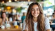 © LifeMedia - Joyful long-haired girl enjoying a lively cafe atmosphere while smiling