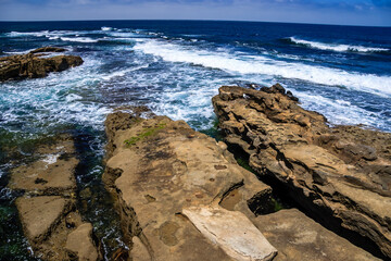 Wall Mural - The ocean is calm and the rocks are jagged