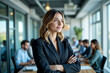 © cyishu - A confident woman in a business suit stands proudly with her team behind her. The nature of empowerment and teamwork, highlighting the power and influence of women in leadership roles.