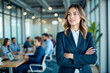 © cyishu - A confident woman in a business suit stands proudly with her team behind her. The nature of empowerment and teamwork, highlighting the power and influence of women in leadership roles.