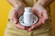 © SR Creative Idea - Woman s Hands Holding White Pill Bottle and Pills Healthcare Concept