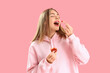© Pixel-Shot - Beautiful young woman eating french fries with ketchup on pink background