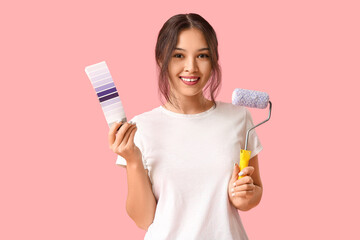 Wall Mural - beautiful young woman with paint roller and palette samples on pink background
