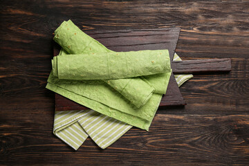 Wall Mural - Board with green lavash on wooden background