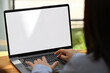 © saltdium - A close-up view of a person typing on a laptop with a blank screen, emphasizing concentration and technology in a workspace