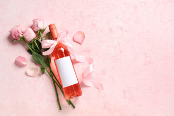 Wall Mural - Bottle of pink wine and beautiful roses on light background