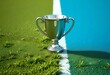 © Ananto - A silver trophy stands proudly on a green field, representing the ultimate goal and the prize for perseverance and hard work