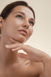 © Buyanskyy Production - A close-up portrait of a young woman with flawless, glowing skin gazing upward with a serene expression. Ideal for skincare, beauty, wellness, and self-care promotional content.
