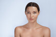 © Buyanskyy Production - Minimalistic portrait of a young woman with glowing skin, staring directly at the camera. The soft light and clean background enhance her flawless complexion, ideal for skincare, beauty, and wellness