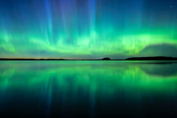 Wall Mural - northern lights dancing over calm lake in north of sweden