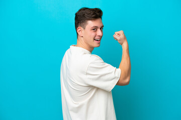 Wall Mural - Young handsome Brazilian man isolated on blue background doing strong gesture