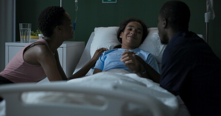 Wall Mural - African girl lying in a hospital room with a book in her hands, reading .