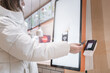 © Vladimir Razgulyaev - A satisfied customer is using a contactless payment system at a modern fast food kiosk, enjoying convenience, A woman pays with a card for a purchase through a touchscreen terminal for ordering food