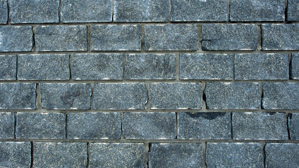Poster - Wall of stones. Brick wall. Gray background with black geometric patterns, of rectangular stones, bricks. Part of a stone wall pattern for background, texture or text. rough grainy stone wall