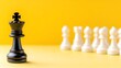 © Amornrat - A black king chess piece stands out against a row of white pawns on a vibrant yellow background, symbolizing leadership and strategy in the game of chess.