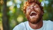 © Freshpixel - A cheerful young man with curly hair is enjoying a beautiful day in nature, laughing heartily as he connects with the environment, radiating joy and positivity.
